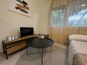 a living room with a table and a tv and a bed at Cozy Corner in Alexandroupoli