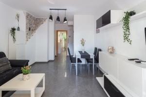 eine Küche und ein Wohnzimmer mit einem Sofa und einem Tisch in der Unterkunft Delfines in Xeraco