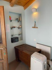 um pequeno quarto com uma mesa e um frigorífico em Tiny Big House em Fanari