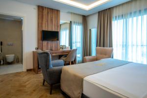 a hotel room with a bed and a desk at CİTY POİNT BEACH&SPA HOTEL in Didim