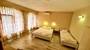 - une chambre avec 2 lits et une fenêtre dans l'établissement Hotel Divna, à Krumovgrad