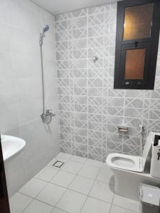 y baño con aseo y lavamanos. en One Bedroom Al Hail DT, en Ḩayl Āl ‘Umayr