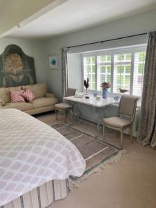 1 dormitorio con 1 cama, mesa y sillas en The Hayloft, en Bridport