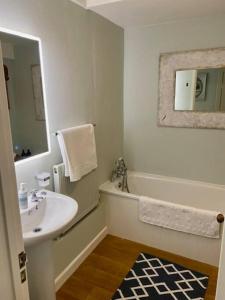a white bathroom with a sink and a mirror at The Hayloft in Bridport