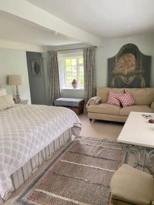 a bedroom with a bed and a couch at The Hayloft in Bridport