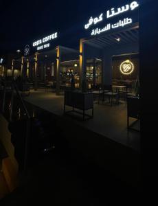 un restaurante iluminado por la noche con mesas y sillas en One Bedroom Al Hail DT, en Ḩayl Āl ‘Umayr