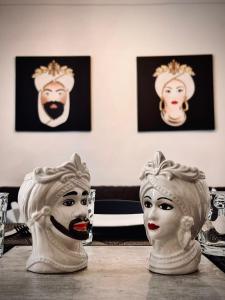 twee witte maskers bovenop een tafel bij Amira Apartments Trapani in Trapani