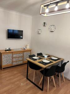 een eetkamer met een tafel met stoelen en een tv bij Amira Apartments Trapani in Trapani