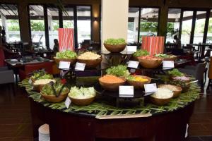 Centara Ceysands Resort & Spa Sri Lanka في بينتوتا: عرض الطعام على طاولة في مطعم