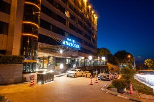 un hotel con coches estacionados en un estacionamiento por la noche en Hotel Anatolia en Bursa