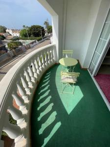uma varanda com um piso verde e uma mesa e cadeiras em Apartamento Club Náutico con piscina em Denia