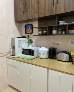 un comptoir de cuisine avec un four micro-ondes. dans l'établissement FaZie Homestay Seri Nuang, à Shah Alam