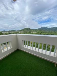 - un balcon blanc avec de l'herbe verte et une vue dans l'établissement FaZie Homestay Seri Nuang, à Shah Alam