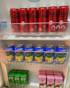 - un réfrigérateur rempli de boissons et de canettes de soda dans l'établissement FaZie Homestay Seri Nuang, à Shah Alam