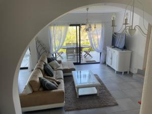 uma sala de estar com um sofá e uma mesa de vidro em Cap Antibes Les Bosquets em Antibes