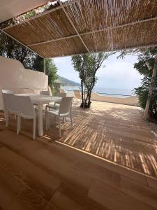 モンテコーリチェにあるVillaggio Dolce Vita Residenceのビーチを望むパティオ(テーブル、椅子付)