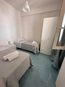 モンテコーリチェにあるVillaggio Dolce Vita Residenceのベッド2台とキャビネットが備わる客室です。