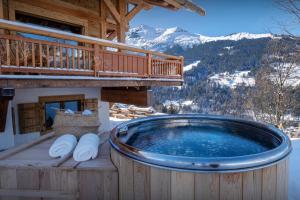 a hot tub on the deck of a log cabin at Chalet Beau Caillou - OVO Network in Saint-Gervais-les-Bains