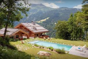 a log home with a swimming pool in front of a house at Chalet Beau Caillou - OVO Network in Saint-Gervais-les-Bains