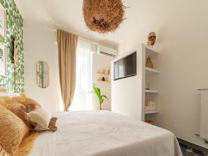 a bedroom with a bed and a tv on the wall at LA CASITA in Alassio