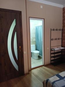 a bathroom with a toilet and a sliding glass door at MANGO Guesthouse in Sighnaghi