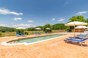 einen Pool mit blauen Stühlen und Sonnenschirmen in der Unterkunft Villa Santarcangelo With Pool - Happy Rentals in Asciano