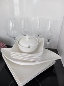 a white plate with a bowl and four wine glasses at Hausboat David in Hrdoňov
