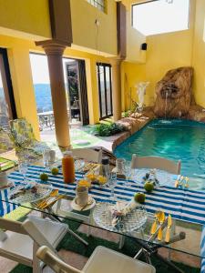 a dining room with a table and a swimming pool at Maupa Mountain view in Krugersdorp