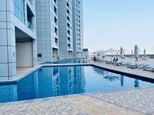 a swimming pool in front of a building at Holiday Homes Amazing 2 Bedroom City Skyline View in Ajman 