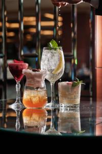 een tafel met drie cocktails en twee wijnglazen bij Hilton Warsaw City Hotel in Warschau +58 foto's