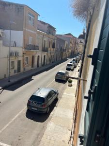een straat met auto's aan de kant van de weg bij Monolocale via centrale in Sorso