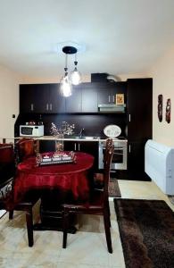 a kitchen with a table with a red table cloth at Classic House Hotel in Korçë