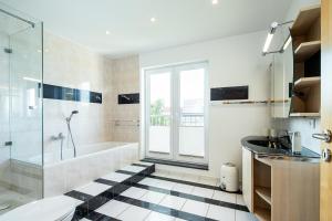 ein Badezimmer mit Badewanne, Dusche und Waschbecken in der Unterkunft Haus Annelie FEWO 3 EG/OG in Dranske