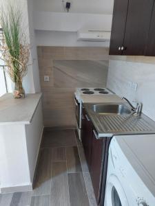 a small kitchen with a stove and a sink at Apartmani Kasteljan 12, Stara Novalja in Stara Novalja