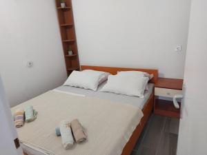 a small room with a bed with towels on it at Apartmani Kasteljan 12, Stara Novalja in Stara Novalja +7 photos