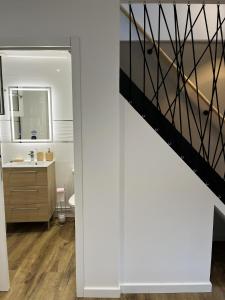 een badkamer met een wastafel en een trap bij Le Duplex in Auxerre