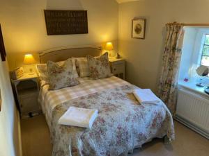 a bedroom with a bed with two towels on it at Sycamore cottage in Matlock