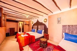 a bedroom with two beds with blue and red sheets at Riad Sidi Mimoune & Spa in Marrakesh