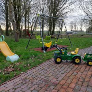 a playground with toy tractors and a swing at Appartement Sandwater in Ihlow