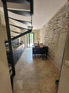 a kitchen with a table and a stone wall at Appartement 2 pers + terrasse in Saint-Rémy-de-Provence