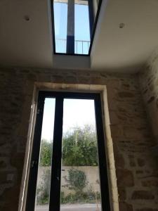 a large window in a room with a stone wall at Appartement 2 pers + terrasse in Saint-Rémy-de-Provence