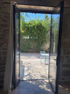 an open door to a patio with tables and chairs at Appartement 2 pers + terrasse in Saint-Rémy-de-Provence