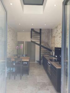 a kitchen with a table and a staircase in it at Appartement 2 pers + terrasse in Saint-Rémy-de-Provence