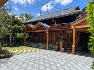 een huis met een gambrel dak en een patio bij Villa Gỗ - Mộc Châu in Mộc Châu