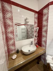 La salle de bains est pourvue d'un lavabo et d'un miroir. dans l'établissement Suites Cielo Stellato on Concordia Sea, à Salerne