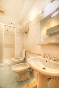 een witte badkamer met een toilet en een wastafel bij The Nest-apartment a stone's throw from the center in Siena