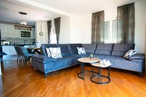 - un salon avec un canapé bleu et une table dans l'établissement Villa Musulin, à Metković