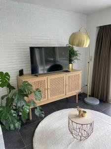 een woonkamer met een tv en een tafel bij Perfect getaway in Bruges! in Brugge