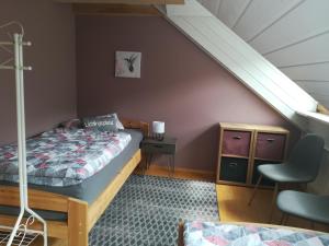 a bedroom with a bed and a chair and a staircase at Ferienwohnung Hopfengärtner in Hiltpoltstein