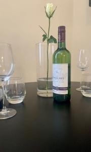 uma garrafa de vinho sentada numa mesa com copos em Studio apartment, The Suffolks. em Cheltenham